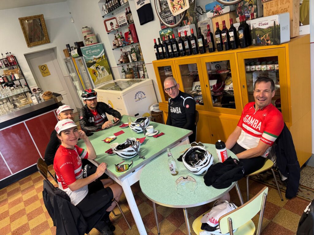 inGamba bike tour crew enjoying time together inside at a table drinking coffee