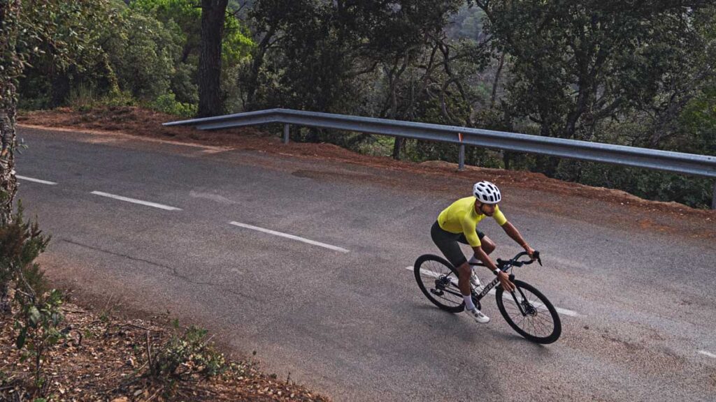 image of a cyclist on a bicycle on a forest road wearing yellow jersey doing zone 2 training for ftp