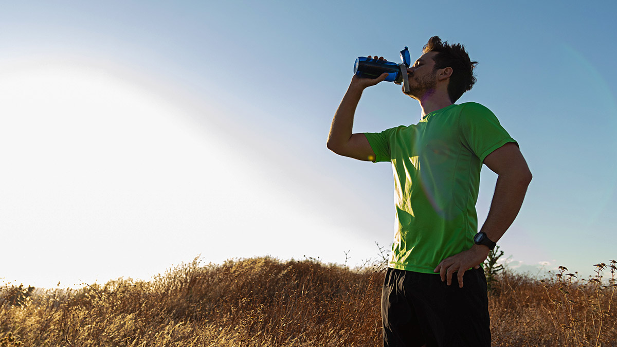 Athlete Drinking Out Of Water Batter With Blue Sky In Background Supplementing With Baking Soda Sodium Bicarbonate