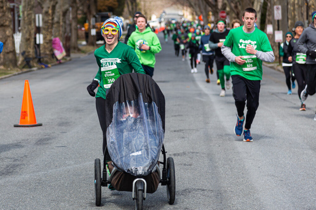 Heather Mayer Irvine using a running stroller in a St. Patrick's Day race with her child