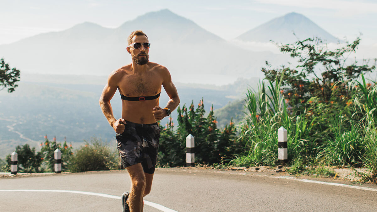 Male Distance Runner Running On Dirt Road In Mountains Shirtless With Chest Strap Heart Rate Monitor