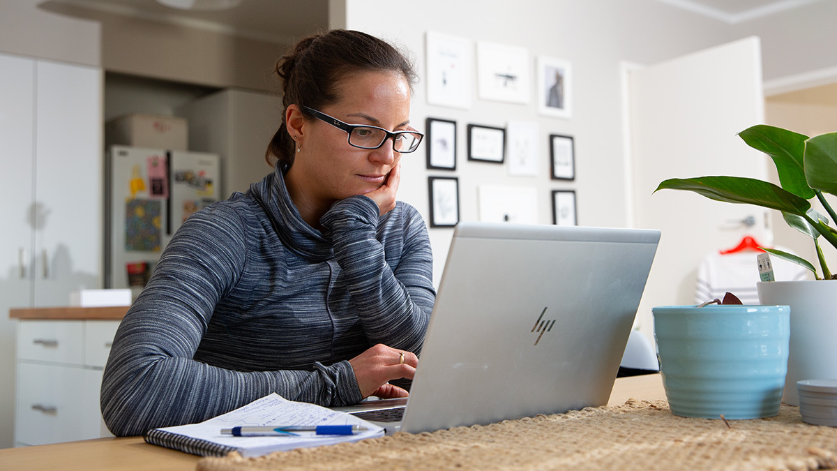 Triathlon Coach Woman Sitting At A Desk On A Computer Making Training Plans For Athletes