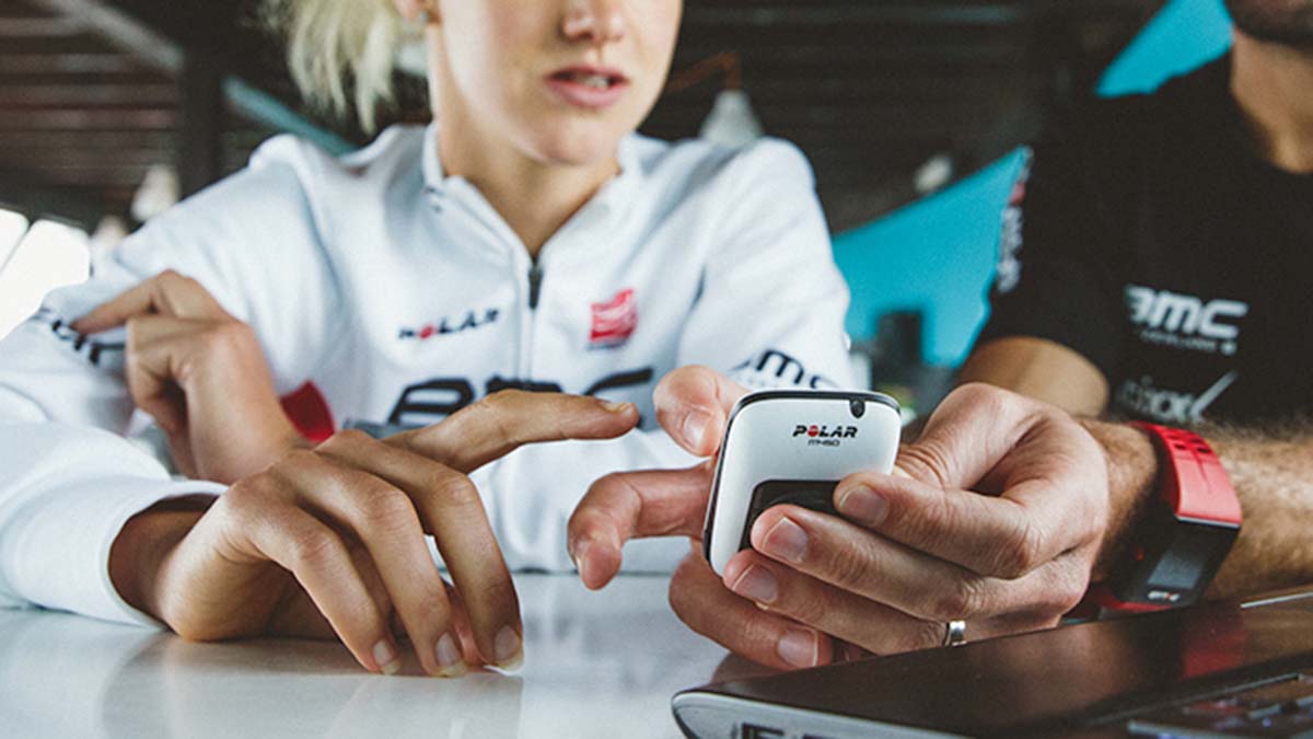 A Pro Triathlete Talking With Her Coach While Looking At A Cyclocomputer